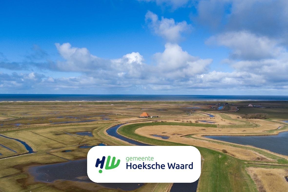 Luchtfoto van het polderlandschap van de Hoeksche Waard met het gemeentelogo